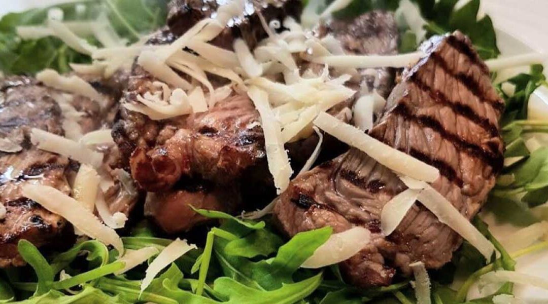 Beef steak slices with rocket salad and parmesan cheese flakes