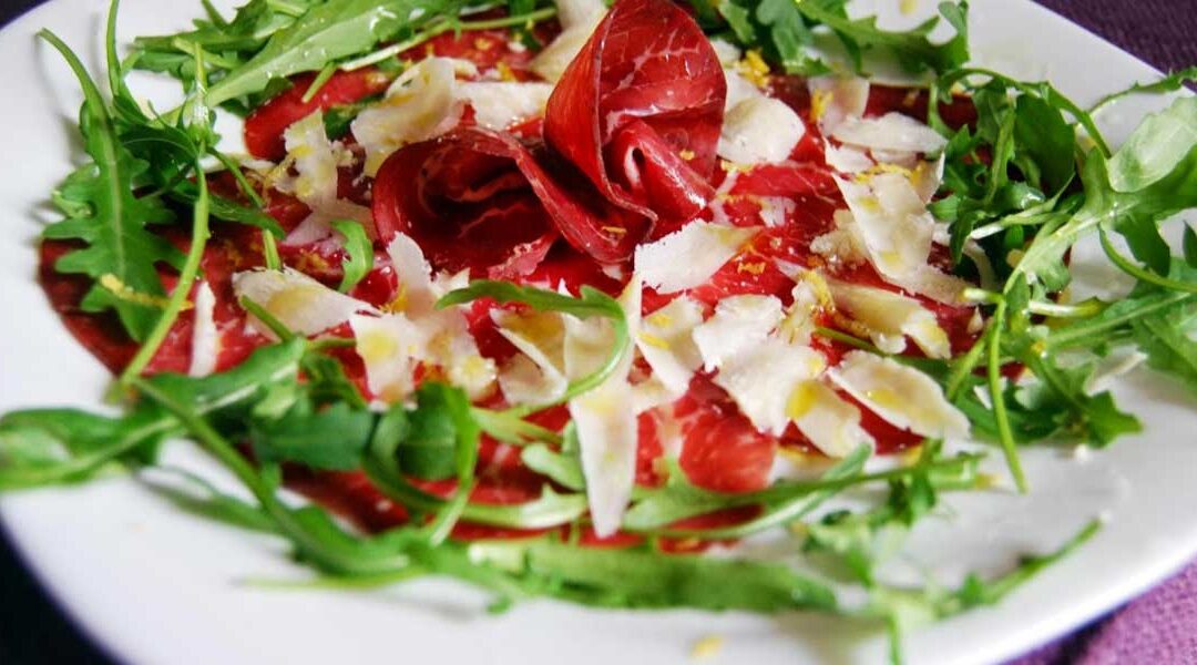 Slices of bresaola air dried beef served with rocket salad